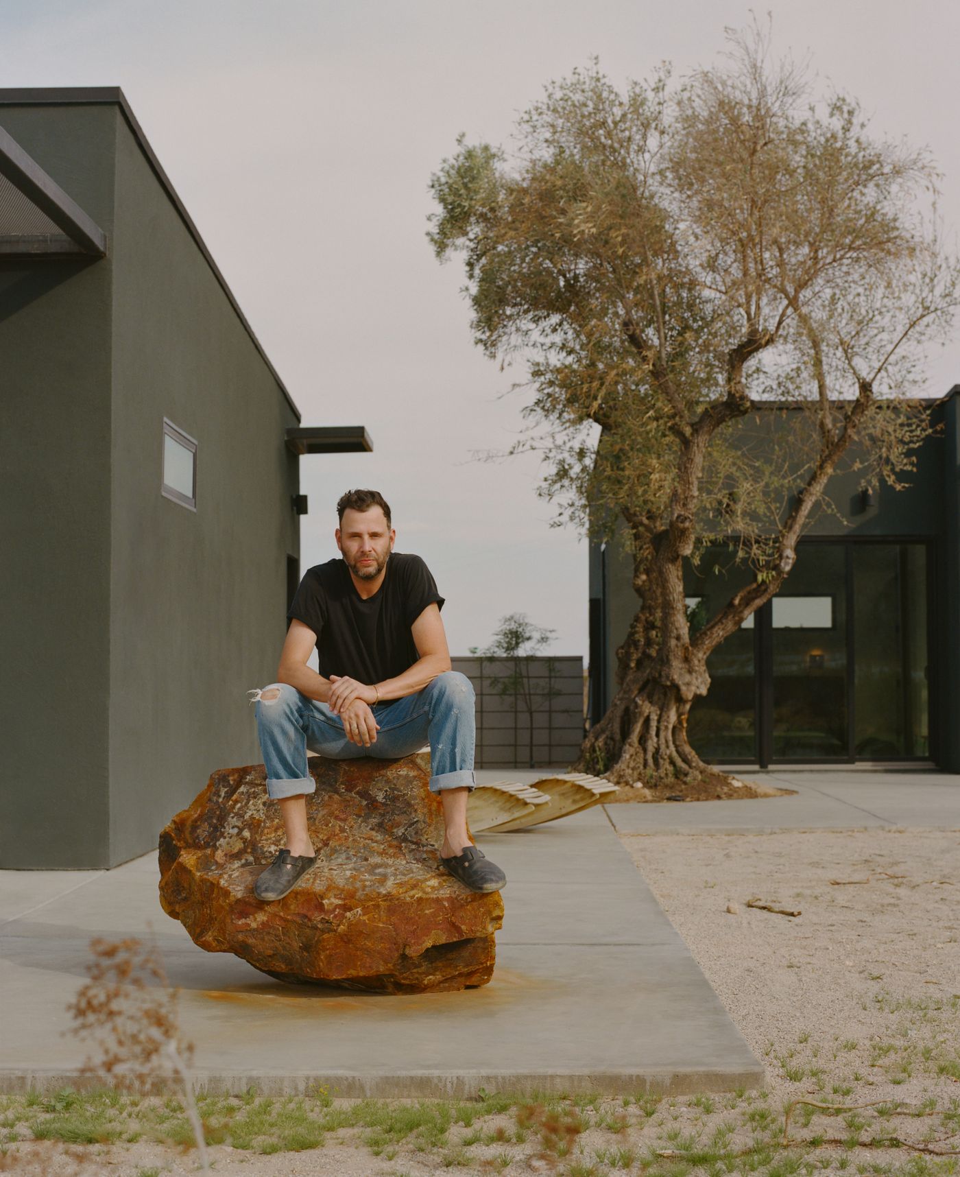 Designer Brian Ware seated on a boulder