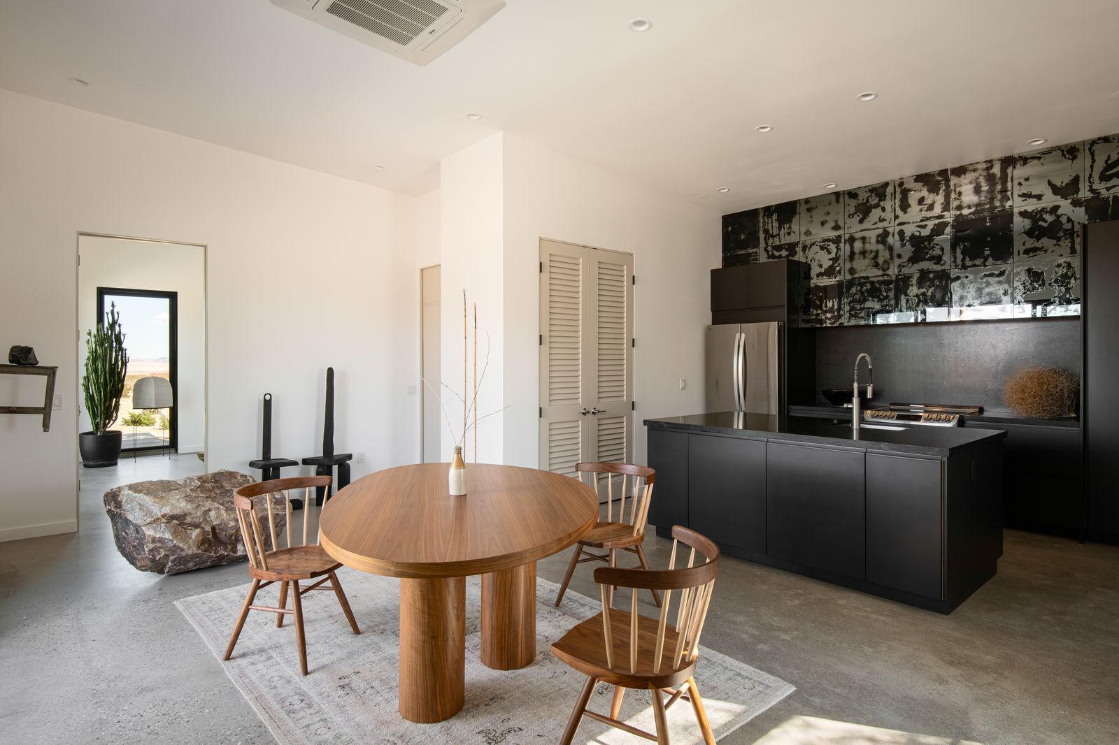 Round oak dining table beside sliding glass