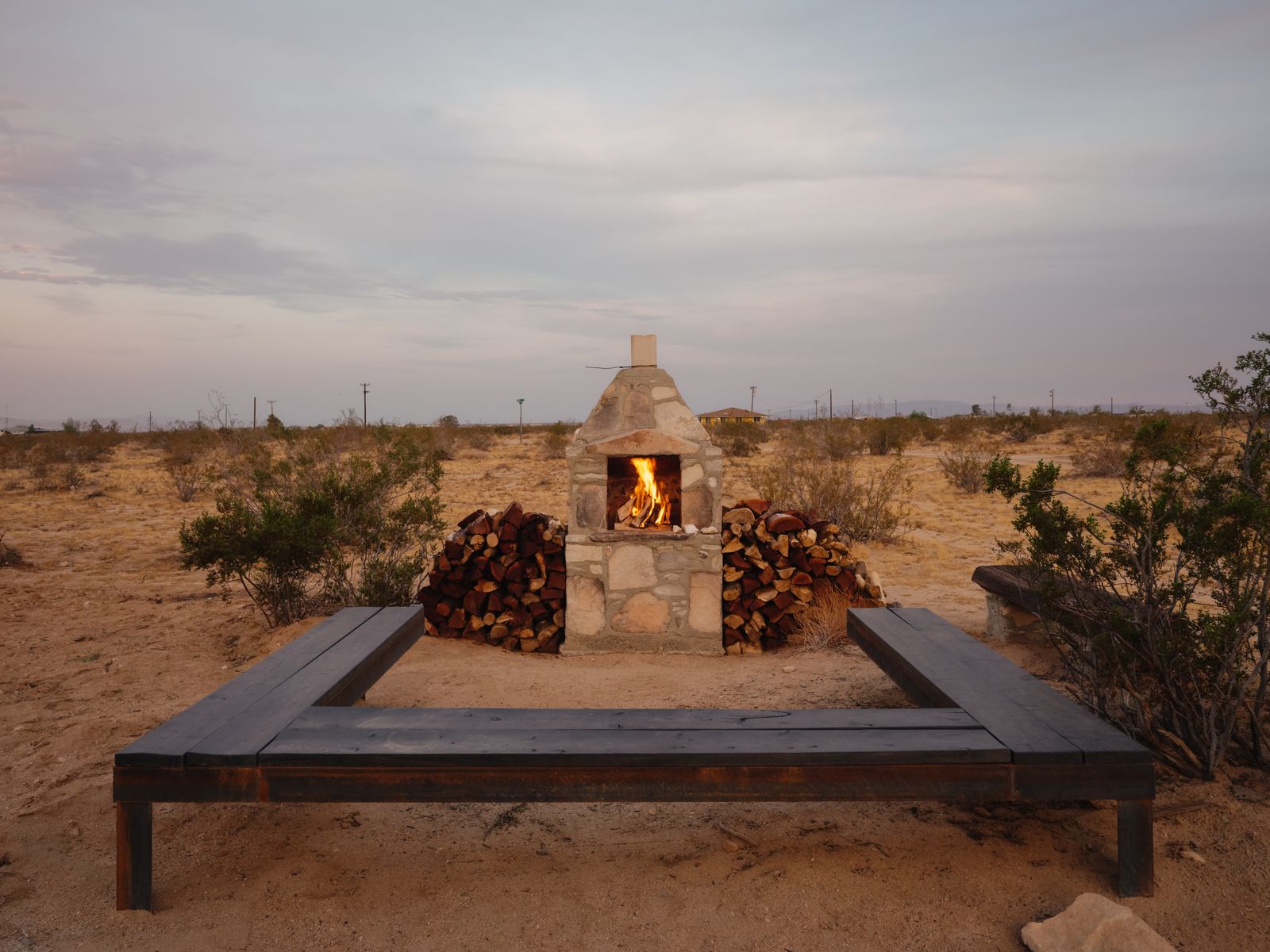Stone fire feature burning at dusk